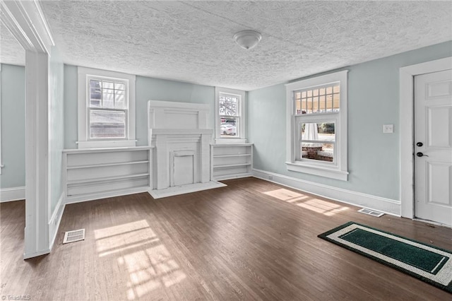 interior space with wood finished floors, visible vents, and baseboards