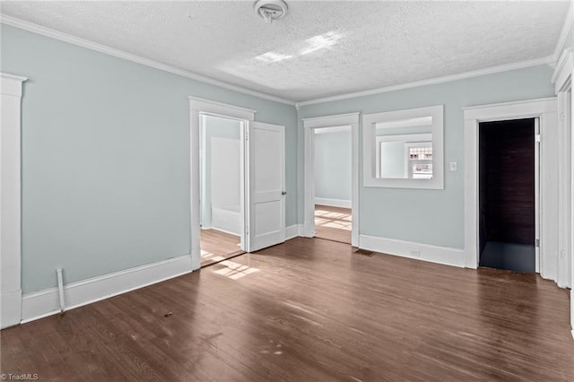 unfurnished bedroom featuring a textured ceiling, ornamental molding, wood finished floors, and baseboards