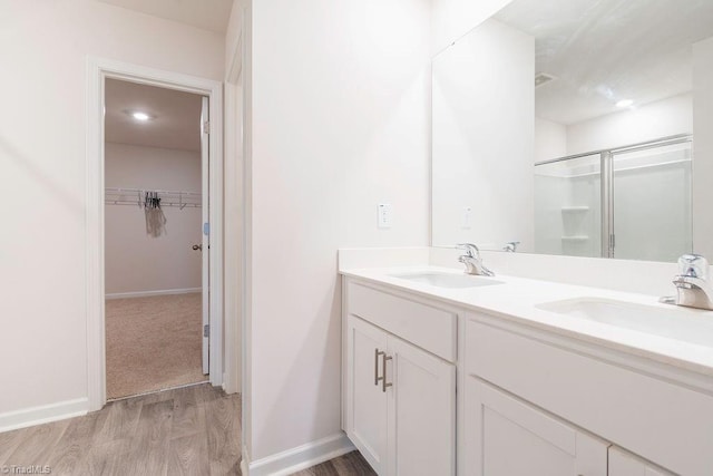 bathroom with vanity, hardwood / wood-style floors, and a shower with shower door