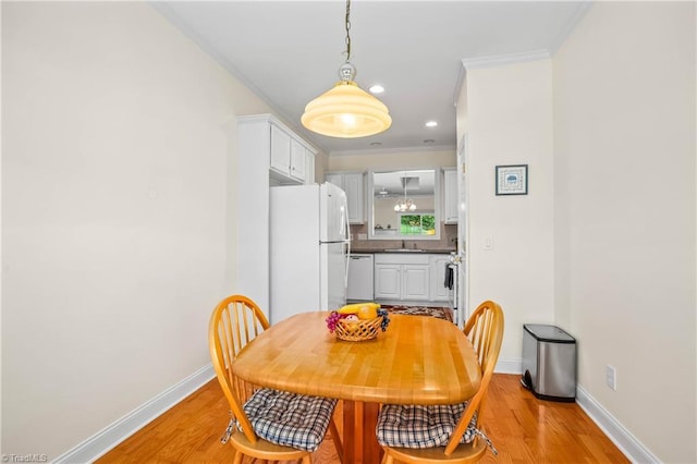 dining space with baseboards, recessed lighting, crown molding, and light wood-type flooring