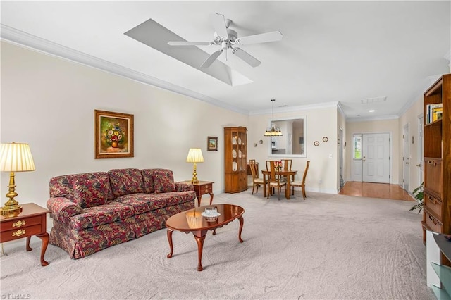 carpeted living area featuring crown molding, baseboards, ceiling fan, and visible vents
