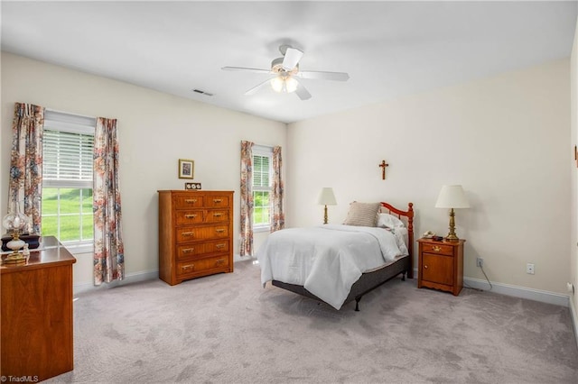 carpeted bedroom featuring baseboards, multiple windows, and visible vents