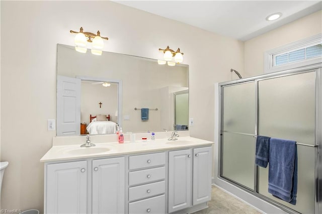 ensuite bathroom featuring double vanity, a sink, connected bathroom, and a stall shower