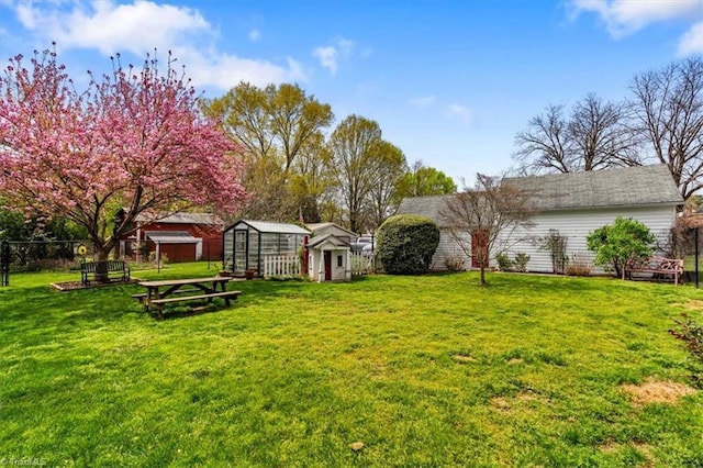 view of yard with a storage shed, fence, and an outbuilding