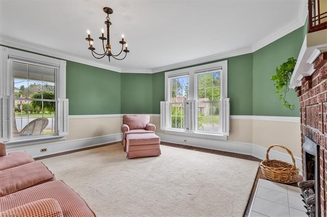 living area featuring a fireplace, ornamental molding, baseboards, and a notable chandelier