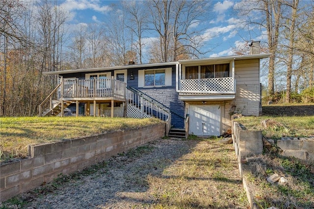 rear view of house with a garage and a wooden deck