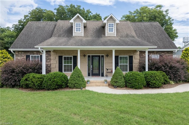 cape cod home featuring a front lawn