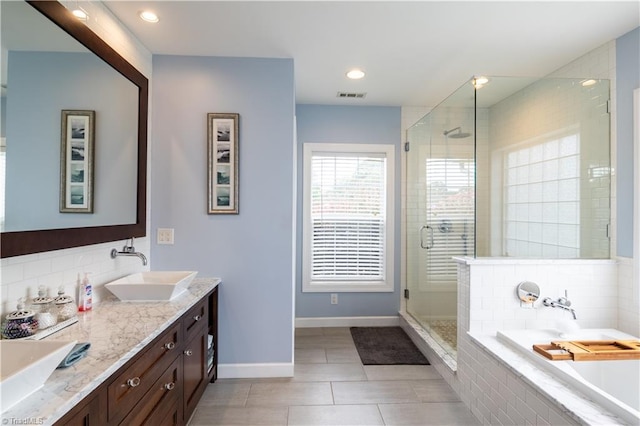 bathroom with plus walk in shower, vanity, tile patterned floors, and backsplash