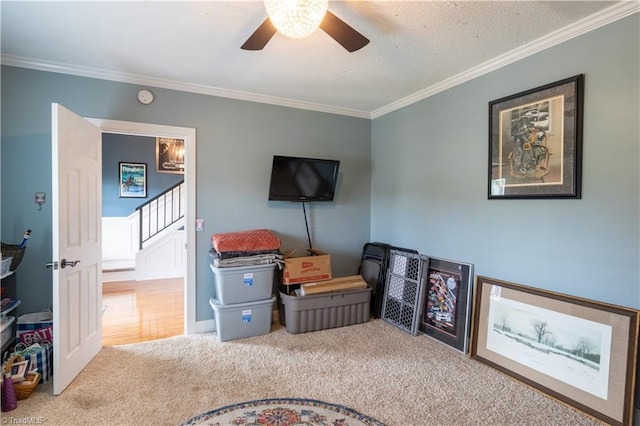 interior space with carpet, crown molding, and ceiling fan