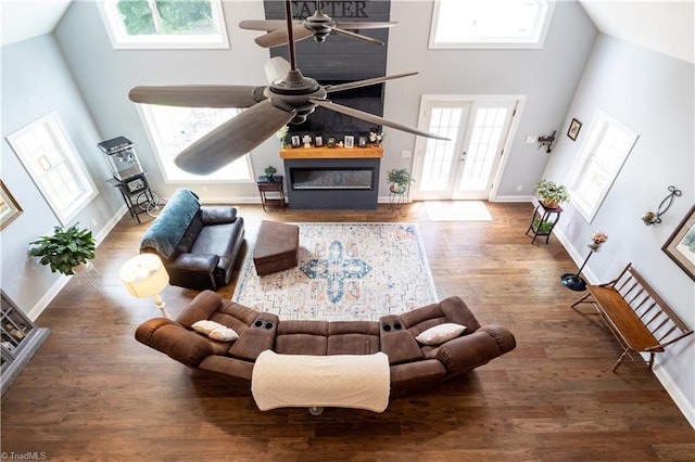 living room featuring high vaulted ceiling, a healthy amount of sunlight, and hardwood / wood-style floors