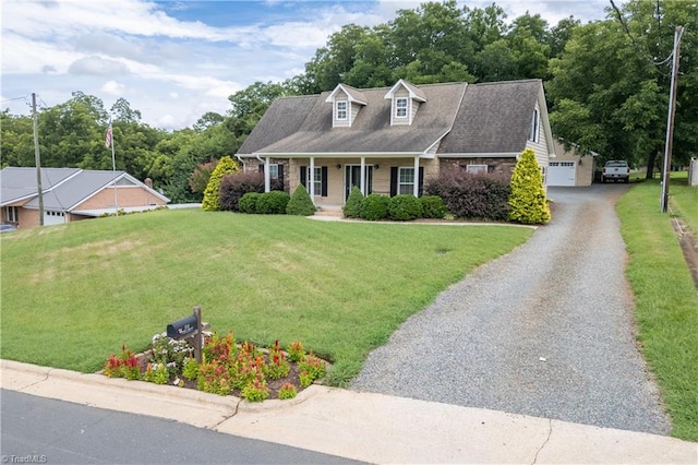 new england style home featuring a garage, a porch, and a front yard