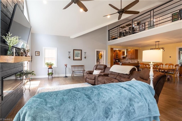 living room featuring a towering ceiling, hardwood / wood-style floors, and ceiling fan