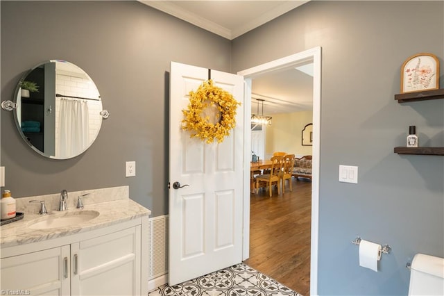 bathroom featuring vanity, crown molding, wood-type flooring, and toilet