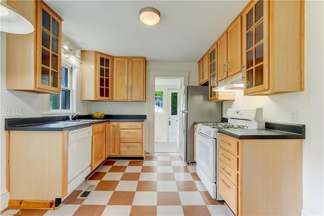 809 Simpson St, Greensboro, NC 27401 - kitchen with white appliances, light floors, glass insert cabinets, under cabinet range hood, and dark countertops