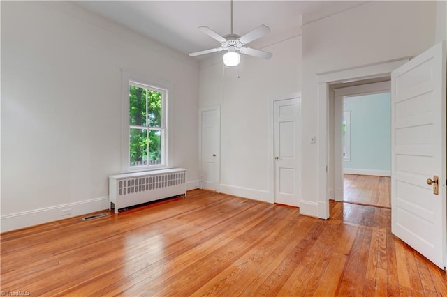 809 Simpson St, Greensboro, NC 27401 - spare room featuring radiator, light wood-type flooring, ceiling fan, and baseboards