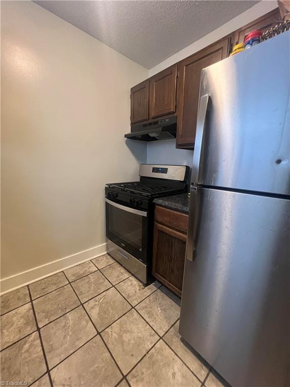 1929 Vantage Point Pl Unit F, Greensboro, NC 27407 - kitchen featuring appliances with stainless steel finishes, under cabinet range hood, light tile patterned floors, a textured ceiling, and dark countertops