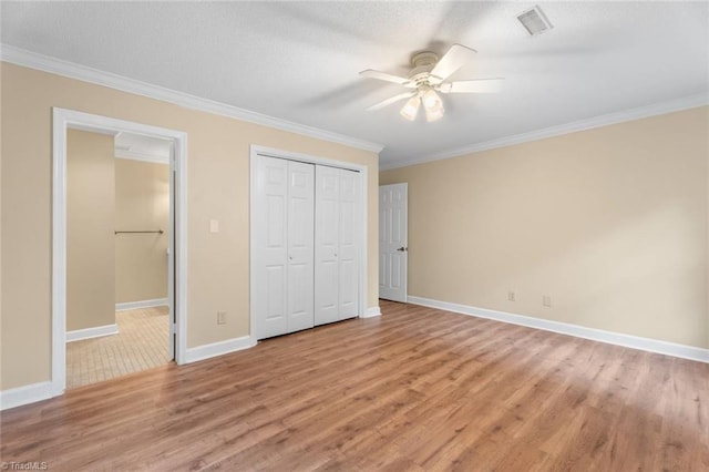 2704 Saint Johns Pl, Winston-Salem, NC 27106 - unfurnished bedroom featuring light wood finished floors, crown molding, baseboards, a ceiling fan, and a closet