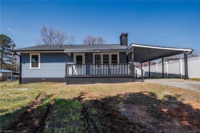 back of property featuring a porch, dirt driveway, crawl space, an attached carport, and a chimney