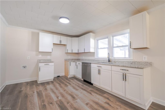 kitchen featuring dishwasher, light wood-type flooring, light stone counters, white cabinetry, and a sink