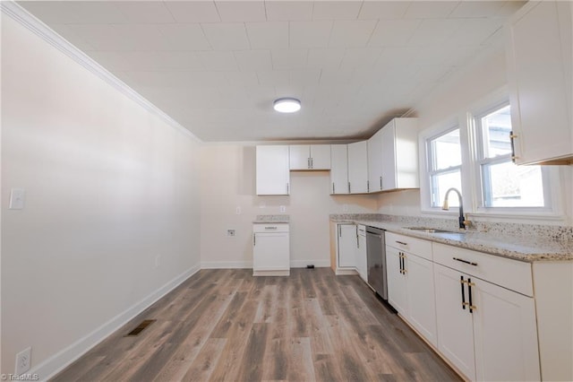 kitchen featuring visible vents, white cabinets, light wood-style floors, and a sink