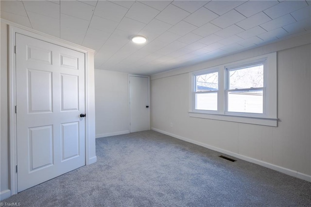 unfurnished bedroom with baseboards, visible vents, and carpet floors