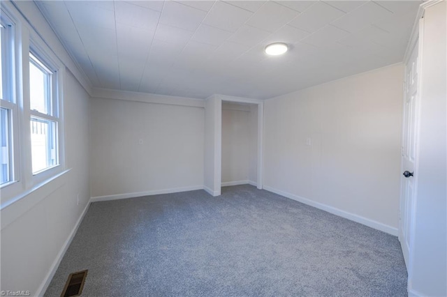 carpeted spare room featuring visible vents and baseboards