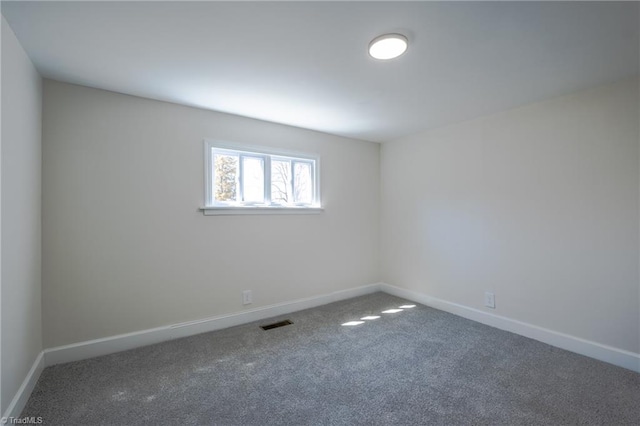 empty room with baseboards, visible vents, and carpet floors