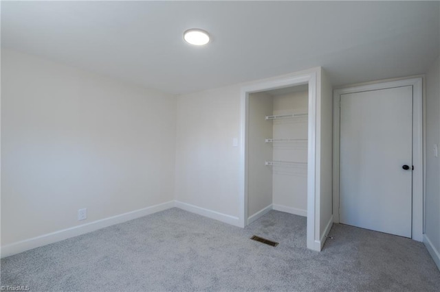 unfurnished bedroom with visible vents, baseboards, carpet, and a closet