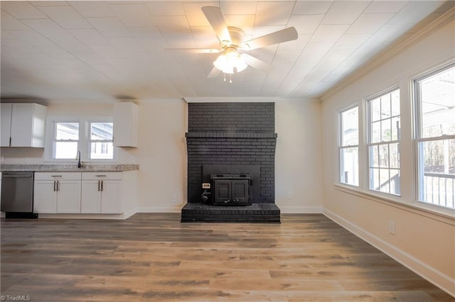 unfurnished living room with light wood-style flooring, baseboards, crown molding, and ceiling fan