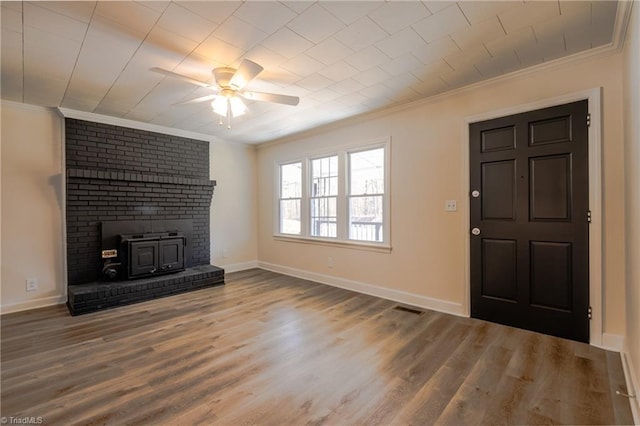 unfurnished living room with baseboards, wood finished floors, ceiling fan, and crown molding