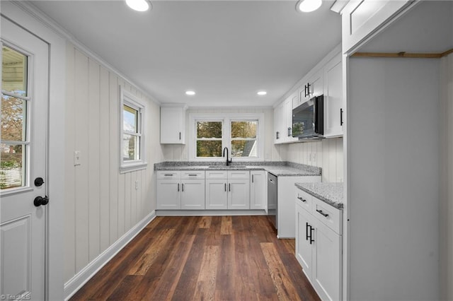 kitchen featuring white cabinets, light stone countertops, stainless steel appliances, and dark wood-type flooring