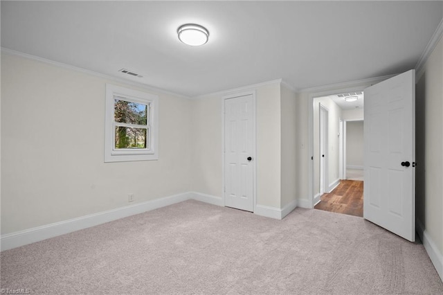 unfurnished bedroom featuring crown molding, a closet, and light colored carpet