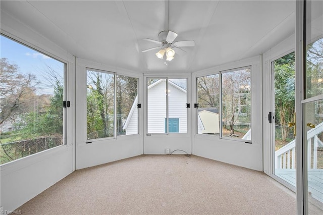 unfurnished sunroom featuring ceiling fan and a healthy amount of sunlight