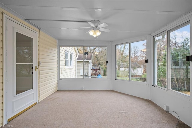 unfurnished sunroom featuring ceiling fan and a healthy amount of sunlight