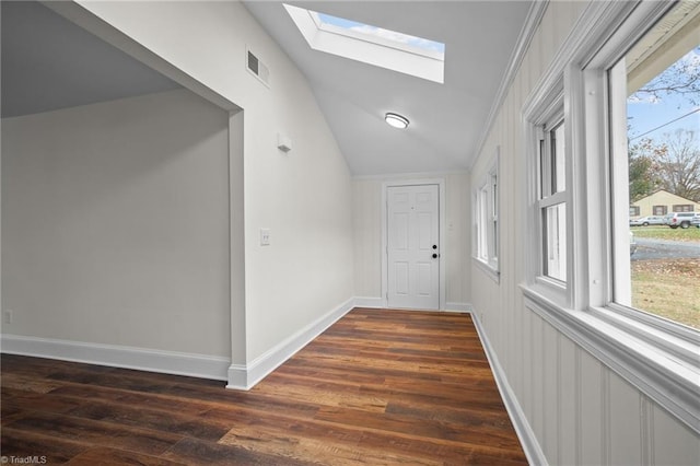 corridor with ornamental molding, dark hardwood / wood-style flooring, and lofted ceiling