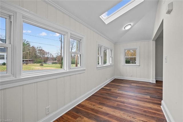 interior space featuring dark wood-type flooring, crown molding, a healthy amount of sunlight, and vaulted ceiling with skylight