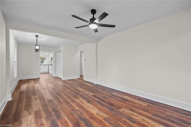 unfurnished living room with ceiling fan and dark wood-type flooring