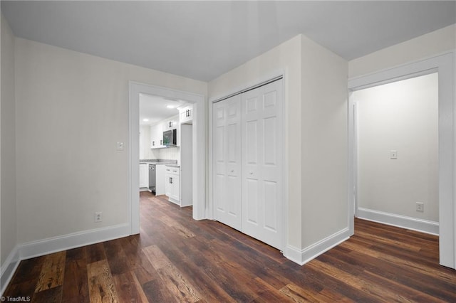 unfurnished bedroom with dark wood-type flooring and a closet