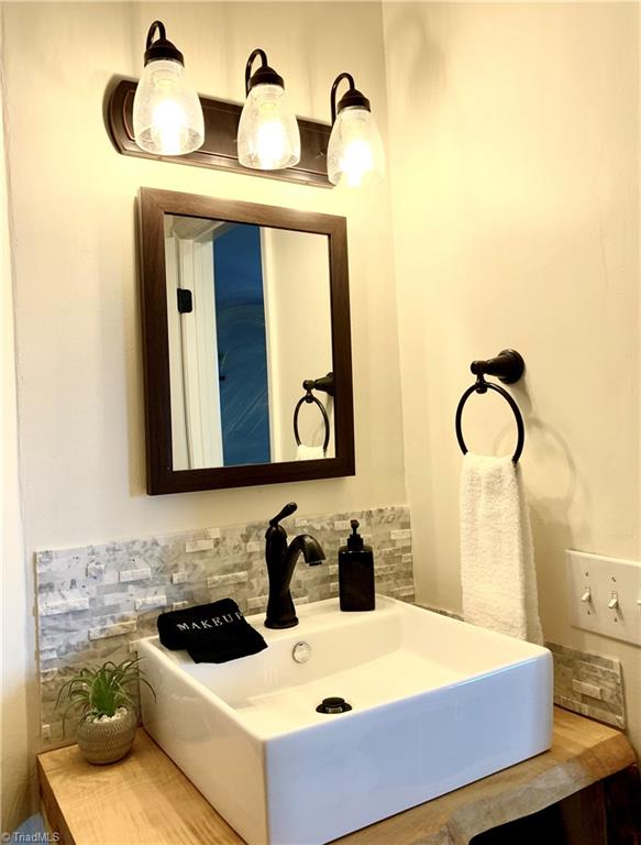 bathroom featuring vanity and tasteful backsplash