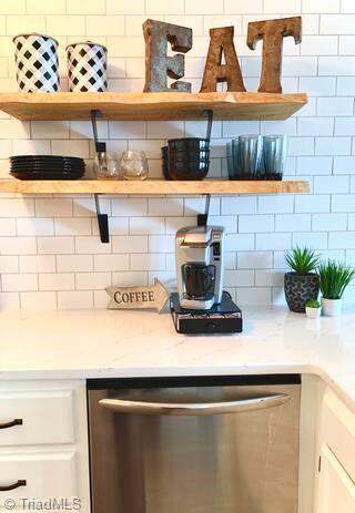 kitchen with dishwasher, tasteful backsplash, white cabinetry, and light stone counters