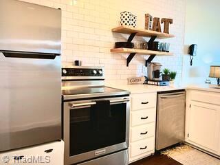 301 Pinnacle Inn Rd Unit 4315, Beech Mountain, NC 28604 - kitchen featuring stainless steel appliances, open shelves, light countertops, decorative backsplash, and white cabinetry