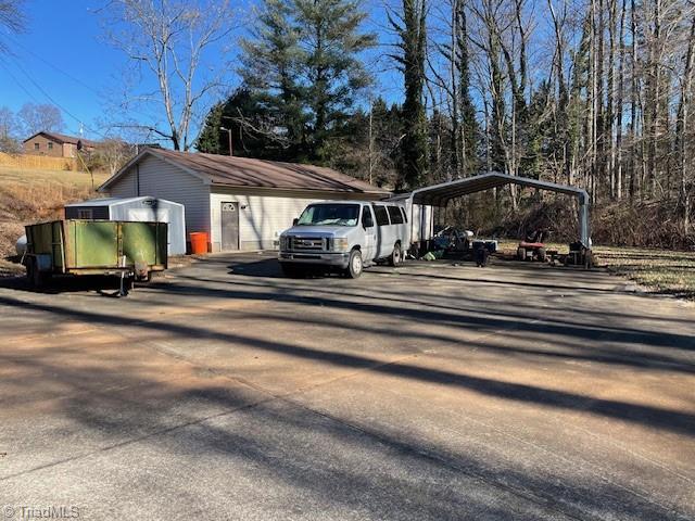 view of vehicle parking with driveway and a detached carport