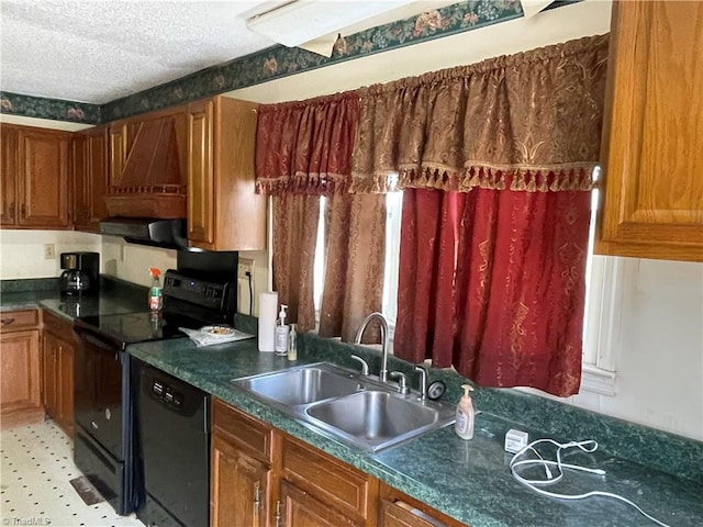 kitchen with dark countertops, brown cabinetry, a sink, a textured ceiling, and black appliances