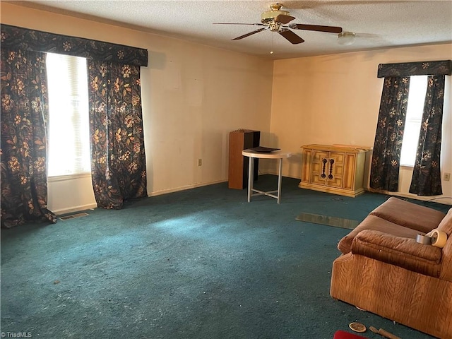 sitting room featuring a textured ceiling, carpet floors, visible vents, and a ceiling fan