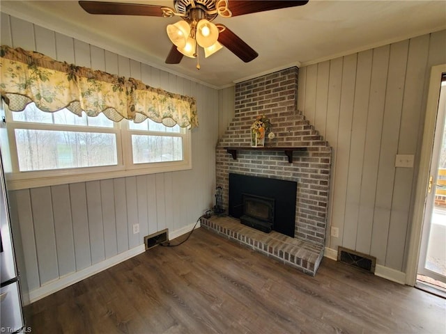 unfurnished living room featuring visible vents, baseboards, and wood finished floors