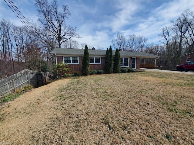 single story home with brick siding, an attached carport, a front lawn, and fence