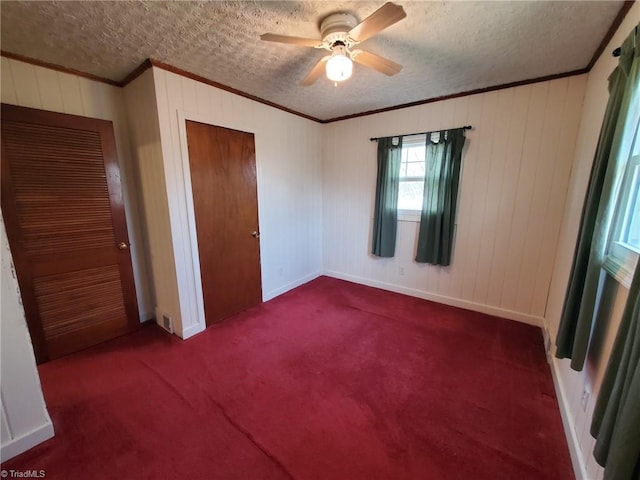 unfurnished bedroom featuring visible vents, ornamental molding, carpet flooring, a closet, and a textured ceiling