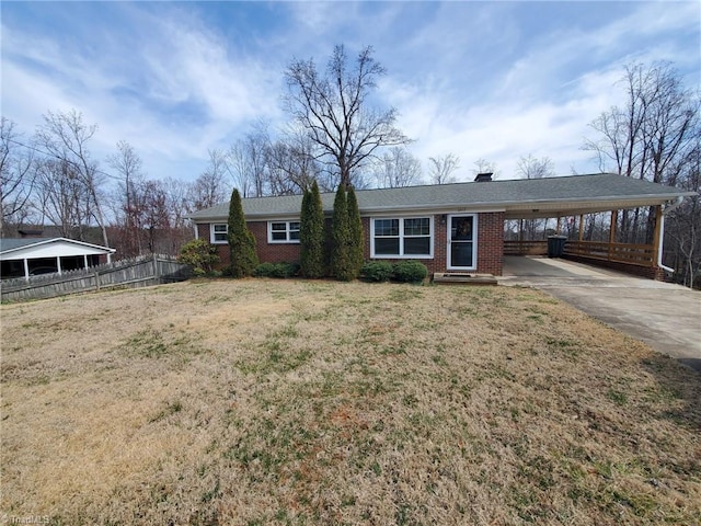 ranch-style house with a carport, concrete driveway, brick siding, and fence