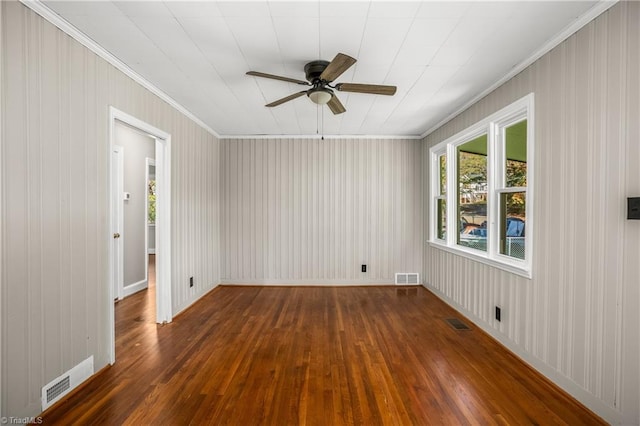 spare room featuring ornamental molding, ceiling fan, and dark wood-type flooring