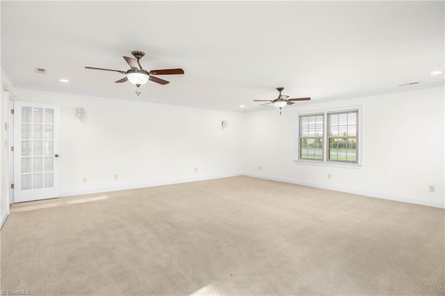 spare room featuring baseboards, light carpet, a ceiling fan, and crown molding